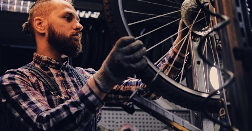 A young man repairing a bicycle tire in a cycling shop